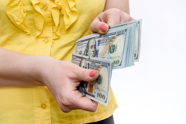 Kobieta trzymając się za ręce stos banknotów dolara z bliska