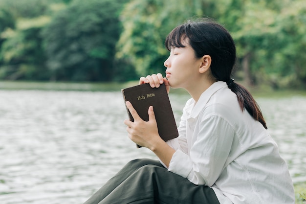 Kobieta Trzymająca Biblię, Naturalne Tło, Jest Wierna Bogu I Kocha Słowo Boże