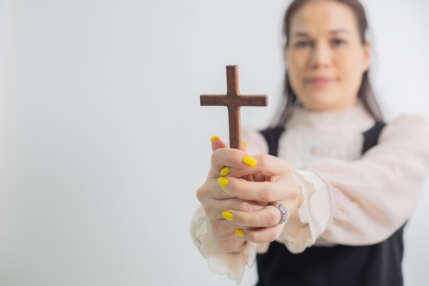 Zdjęcie kobieta trzymająca drewniany krzyż modląca się za religię boga
