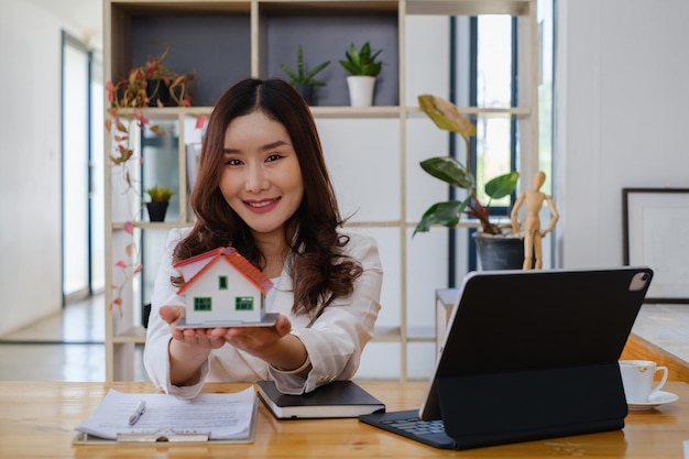 Kobieta trzymająca i sprawdzająca model domu Real Estate House Appraisal And Inspection and Insurance concept