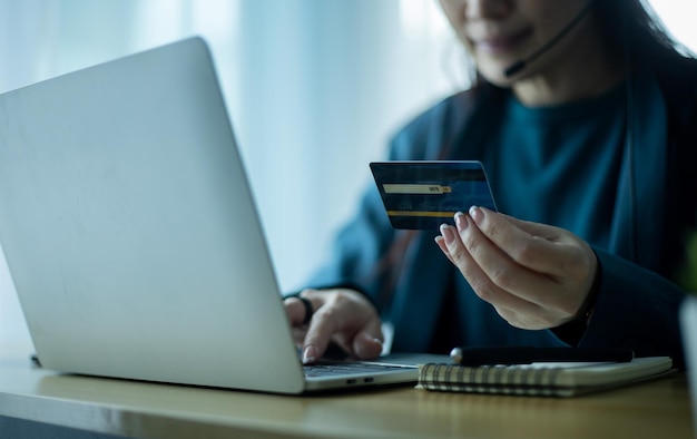 Kobieta trzymająca kartę kredytową i korzystająca z komputera Zakupy online e-commerce bankowość internetowa pracująca z domowej koncepcji