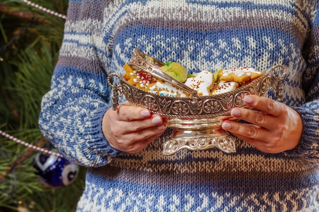 Kobieta trzymająca metalowy wazon z piernikowymi ciasteczkami