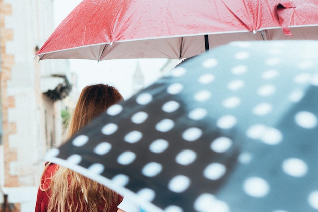Zdjęcie kobieta trzymająca mokry parasol w deszczu