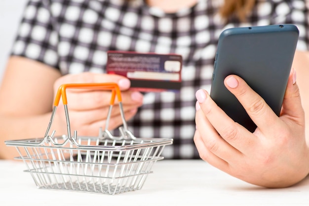 Zdjęcie kobieta trzymająca plastikową kartę kredytową i telefon dokonująca bezpiecznych płatności internetowych