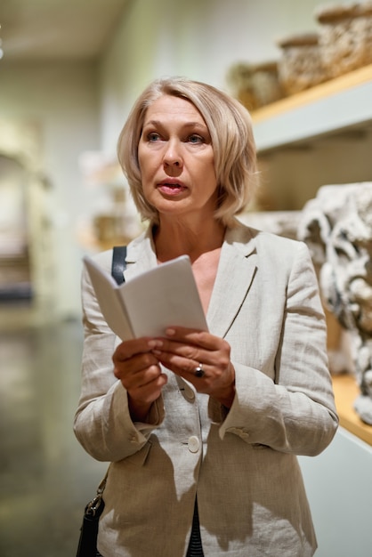 Kobieta trzymająca przewodnik w muzeum