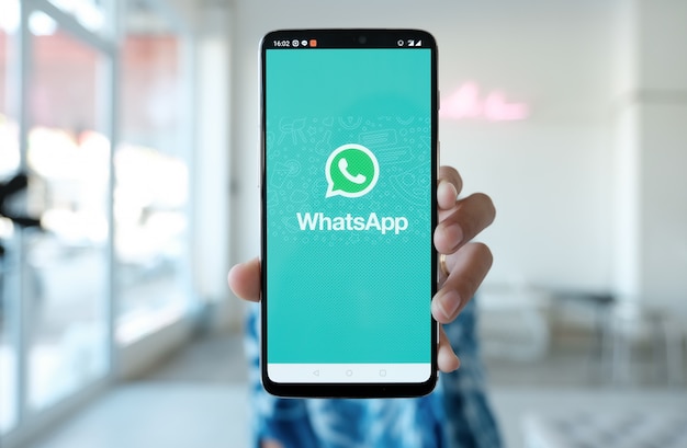 Zdjęcie kobieta trzymająca smartfon z whatsapp na ekranie