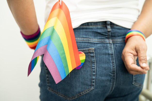 Zdjęcie kobieta trzymająca tęczową kolorową flagę lgbt symbol tolerancji i pokoju dla lesbijek gejów, biseksualistów, transpłciowców