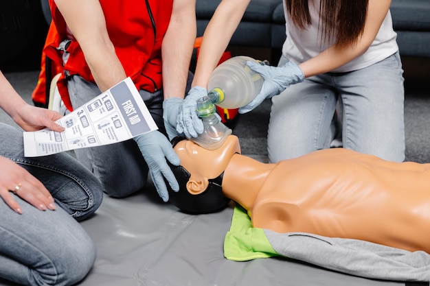 Kobieta trzymająca worek do oddychania Worek Ambu Demonstracja resuscytacji krążeniowo-oddechowej Szkolenie z resuscytacji krążeniowo-oddechowej procedura medyczna na lalce CPR w klasie Ratownik medyczny demonstruje praktykę pierwszej pomocy w celu ratowania życia