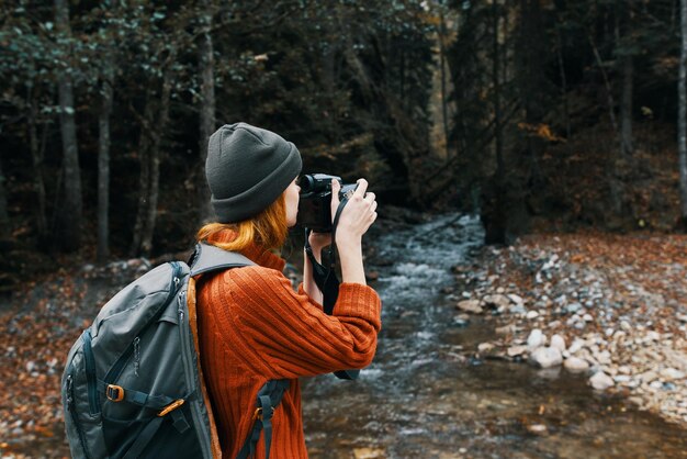 Kobieta turysta fotografująca przyrodę rzeka las góry