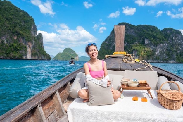 Kobieta turysta w prywatnej podróży łodzią longtail na wyspę z egzotycznym jedzeniem piknik Krabi Tajlandia punkt orientacyjny Azja Podróże wakacje wanderlust i koncepcja wakacji