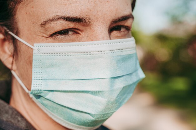 Kobieta ubrana w ochronną maskę chirurgiczną przeciwko chorobom COVID-19