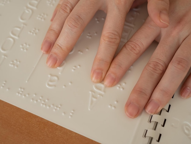 Zdjęcie kobieta uczy się alfabetu braille'a za pomocą dekodera