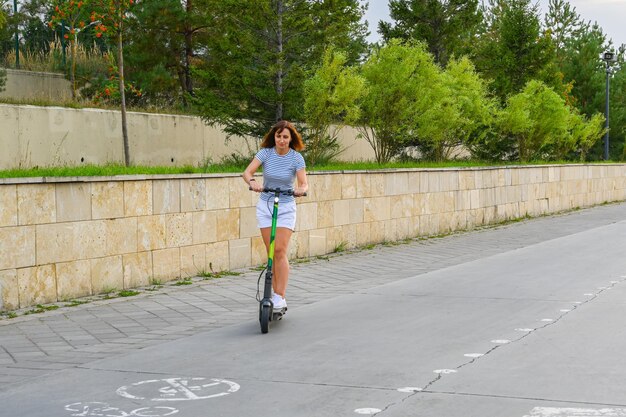 Kobieta uczy się jeździć na hulajnodze na kazańskim skarpie Ekologiczny transport