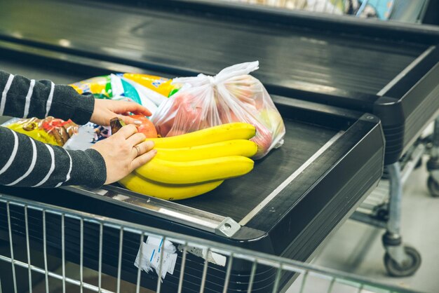 Kobieta układa produkt na linii obok kasy