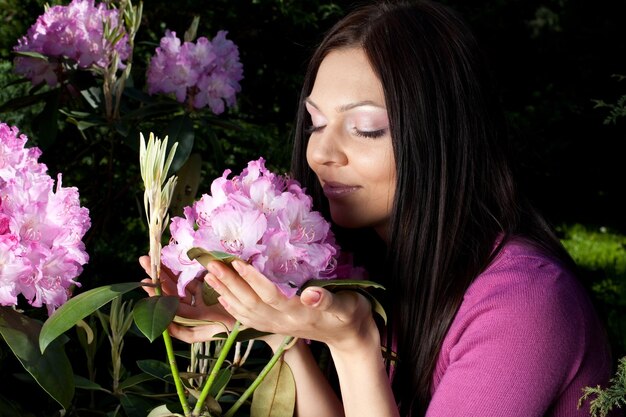 Zdjęcie kobieta uśmiecha się na zewnątrz z niektórych kwiatów