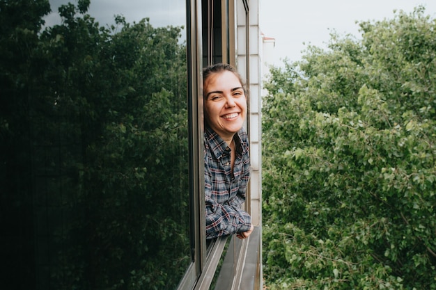 Zdjęcie kobieta uśmiecha się, pokazując okno w mieście w wiosenny dzień