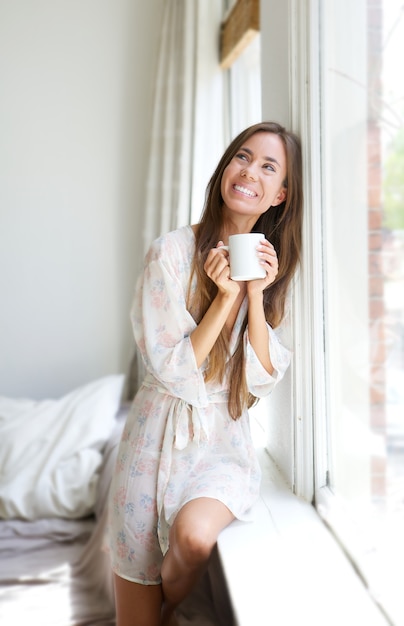 Kobieta Uśmiecha Się Przez Okno Do Picia Herbaty