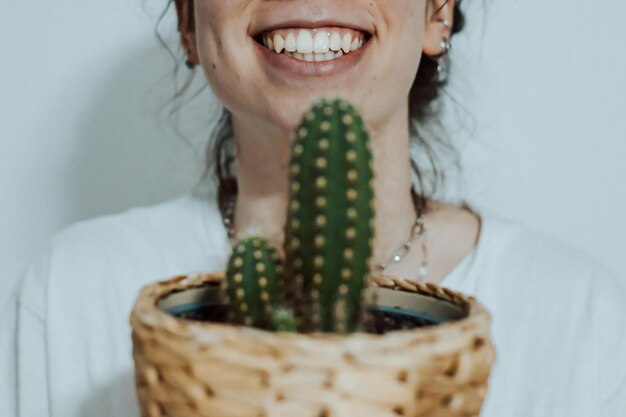 Kobieta Uśmiecha Się Szczęśliwa, Trzymając Różne Rośliny I Kaktusy, Aby Udekorować Swój Nowy Dom Nowoczesna I Stylowa Koncepcja Domu Skopiuj Obraz Przestrzeni
