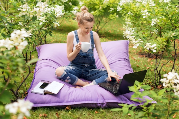 Kobieta używa jej laptop w ogródzie