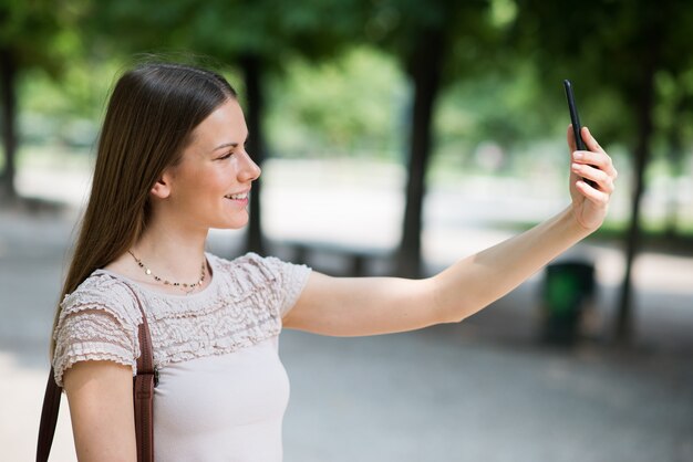 Kobieta używa jej telefon komórkowego brać fotografię