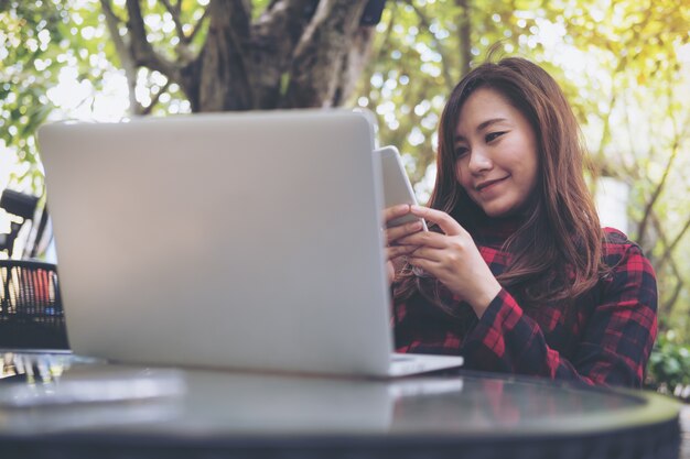 Kobieta używa komputerowego laptop z telefonem