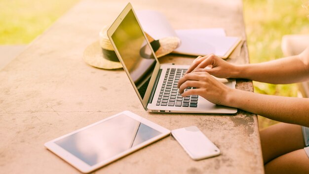 Zdjęcie kobieta używa laptop przy stołem outdoors