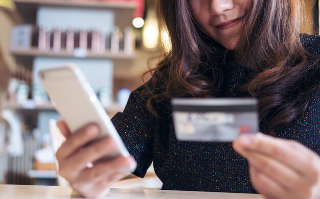 Kobieta używa mądrze telefon i kredytową kartę