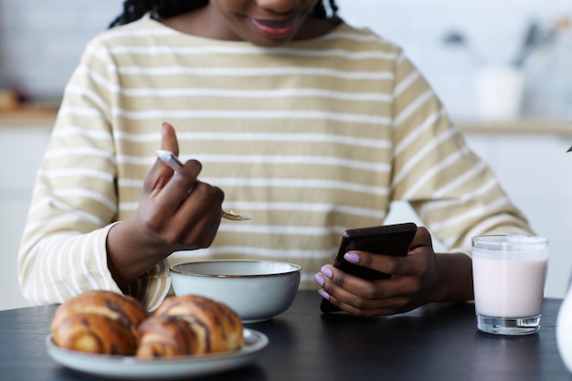 Kobieta używa smartphone podczas śniadania