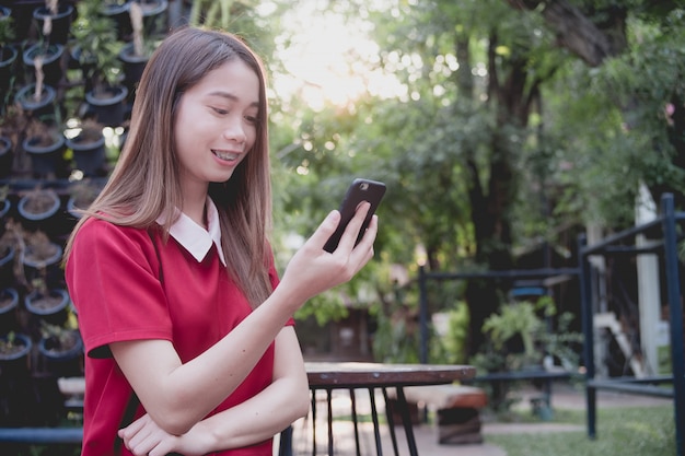 Kobieta używa telefon komórkowego podczas gdy stojak w parku