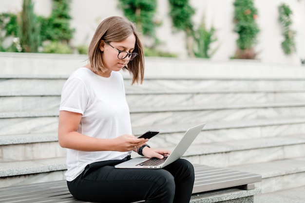 Kobieta Używa Telefonu I Laptopa Na Ulicy