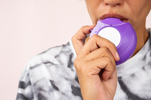 Kobieta używająca inhalatora astmatycznego Nieuznawalna kobieta z przewlekłą astmą z bliska