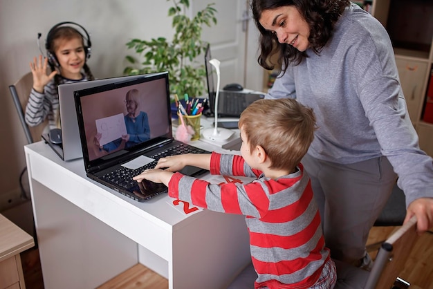 Kobieta używająca telefonu siedząc na laptopie