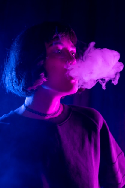 Zdjęcie kobieta vaping z fajki wodnej w pomieszczeniu