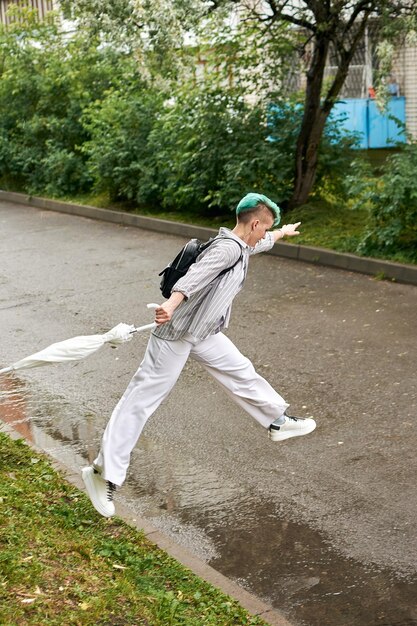 Zdjęcie kobieta w białych ubraniach i parasol pozuje przy kwitnącym krzewie