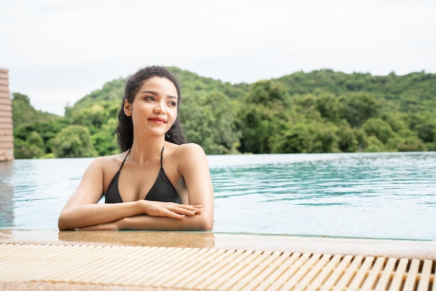 Kobieta w bikini na basenie Basen opalone smukłe i zgrabne ciało Dziewczyna ciesząca się wakacjami w podróży luksusowy bungalow nad wodą