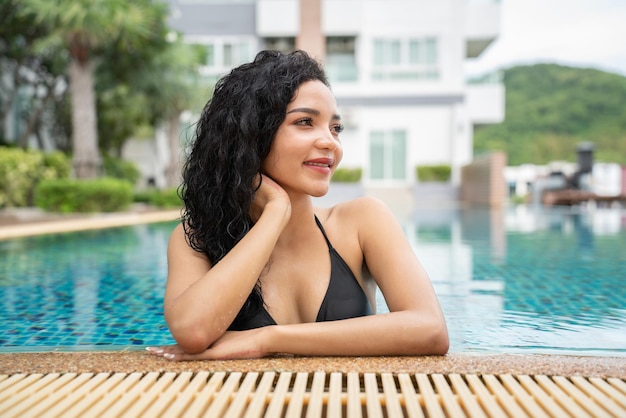 Kobieta w bikini na basenie Basen opalone smukłe i zgrabne ciało Dziewczyna ciesząca się wakacjami w podróży luksusowy bungalow nad wodą