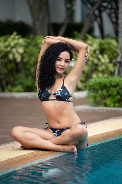 Kobieta w bikini na basenie Basen opalone smukłe i zgrabne ciało Dziewczyna ciesząca się wakacjami w podróży luksusowy bungalow nad wodą