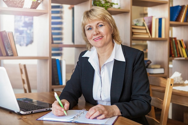 Kobieta w biurze pracuje na laptopie