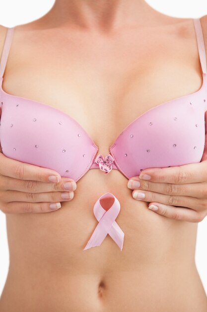 Kobieta w biustonoszu z wstążką świadomości raka piersi