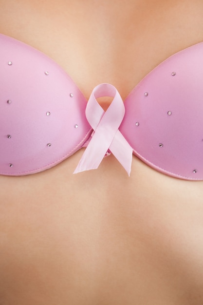 Kobieta w biustonoszu z wstążką świadomości raka piersi