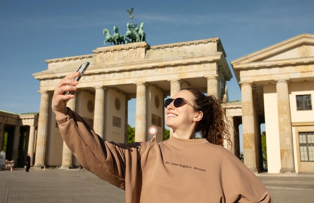 Kobieta W Bluzie Robi Sobie Autoportret Przed Bramą Brandenburską.