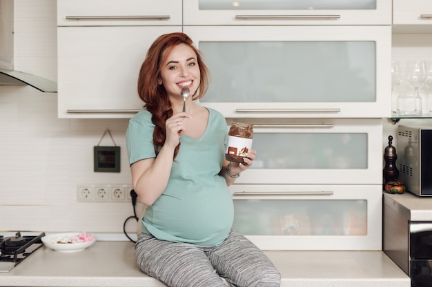 Kobieta w ciąży cieszy się jedzący czekoladę
