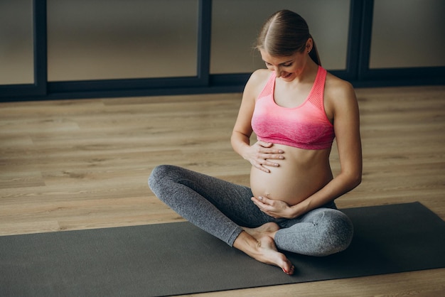 Kobieta w ciąży ćwicząca na zajęciach pilates