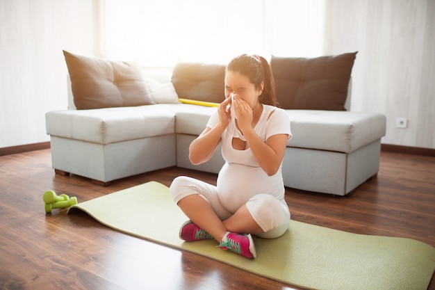 Kobieta W Ciąży ćwiczy Na Macie Do Jogi W Domu. Ciąża I Sport. Joga I Pilates Dla Kobiet W Ciąży. Trzeci Trymestr Ciąży