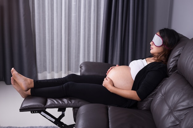 Kobieta w ciąży dosypianie na kanapie
