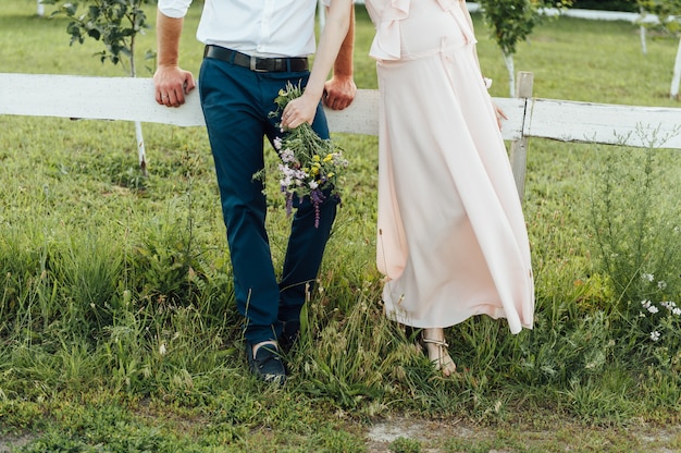 Zdjęcie kobieta w ciąży gospodarstwa kwiaty w parku