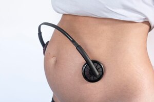 Zdjęcie kobieta w ciąży gospodarstwa słuchawki na brzuch