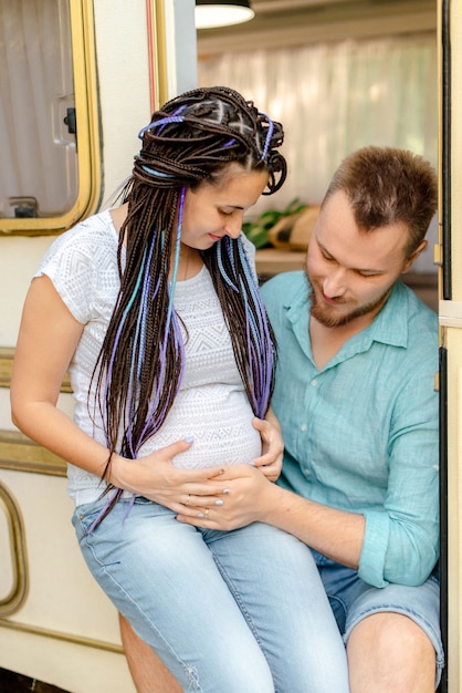 Kobieta w ciąży i jej mąż siedzący w przyczepie