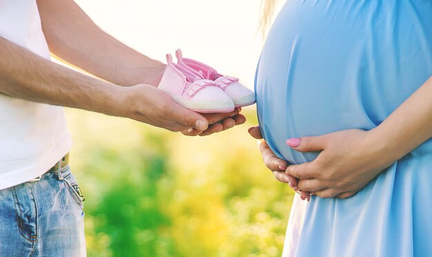 Kobieta w ciąży i mężczyzna trzymają buty dziecięce