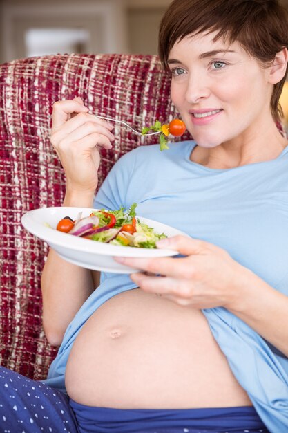 Kobieta w ciąży je sałatki